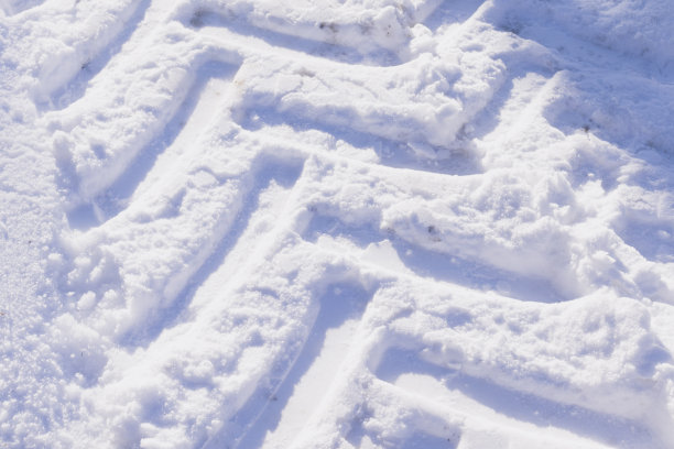 拖拉机的雪胎痕迹。冰雪覆盖的道路。图片下载