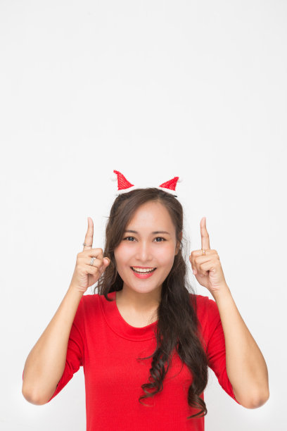 可爱的亚洲女人微笑和快乐提出的东西为圣诞节和新年的概念。图片下载