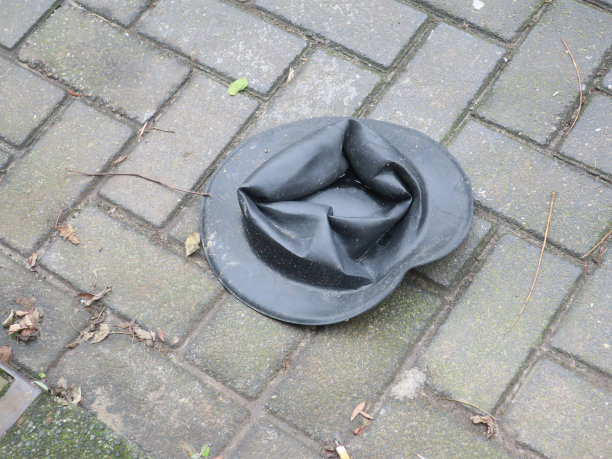 黑色帽子掉在人行道上图片下载