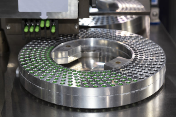 制药厂药品灌装机生产线上的绿色胶囊药丸。医疗技术与行业理念。有选择性的重点。图片下载