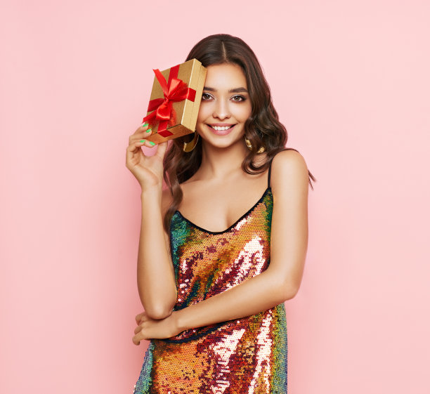 漂亮的女人穿着晚礼服，拿着礼品盒图片下载