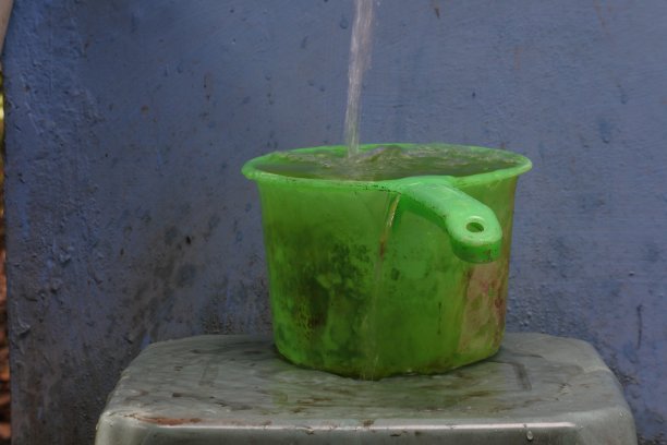 水从黑色的桶里溢出来。满不再适合。过载图片下载