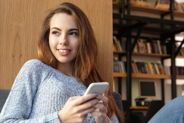 年轻开朗的女学生坐在图书馆聊天图片下载