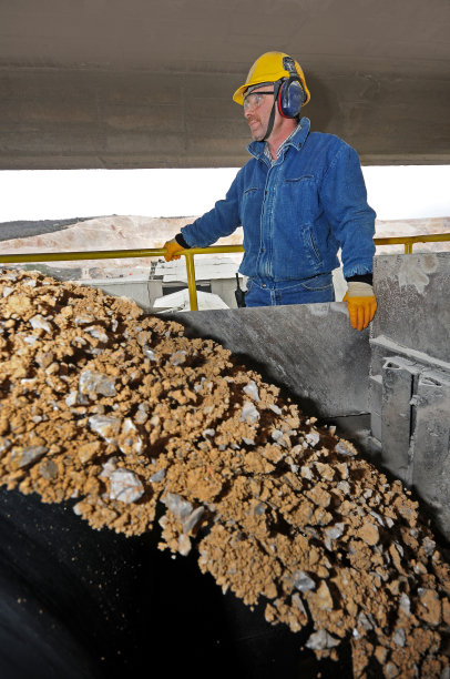 在输送线上控制砂粒的工人图片下载