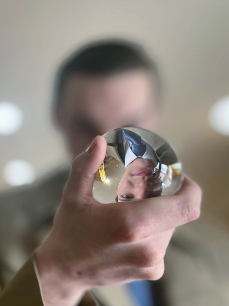 背景照片中手持水晶球的男性人物脸上流露出不确定或紧张的表情图片下载