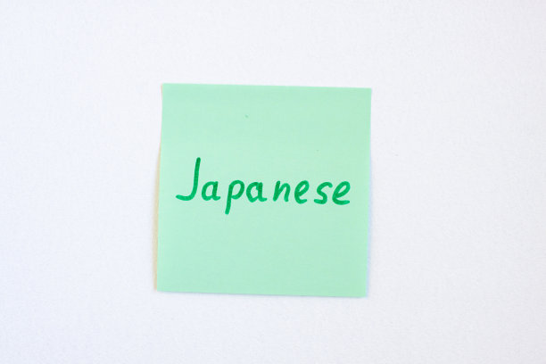 俯视图平铺的提醒笔记纸的绿色与字日本在它的白色背景。抽认卡和语言学习概念图片下载