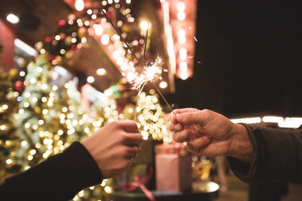 两只手拿着烟火在圣诞节或新年前夕的背景图片下载