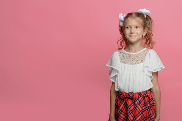 可爱的女学生穿着红色的裙子，背着粉红色的背包。情感上的肖像。回到学校图片下载