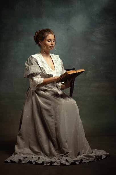 年轻美丽的年轻女孩在中世纪风格的灰色连衣裙孤立在黑暗的背景。时代观念比较，佛兰德风格。图片下载