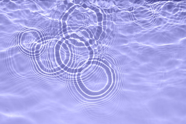 水面上的淡紫色透明的游泳池水。新潮抽象的波浪背景。水波在阳光下飘扬。时髦的横幅与2022年的颜色非常接近。图片下载