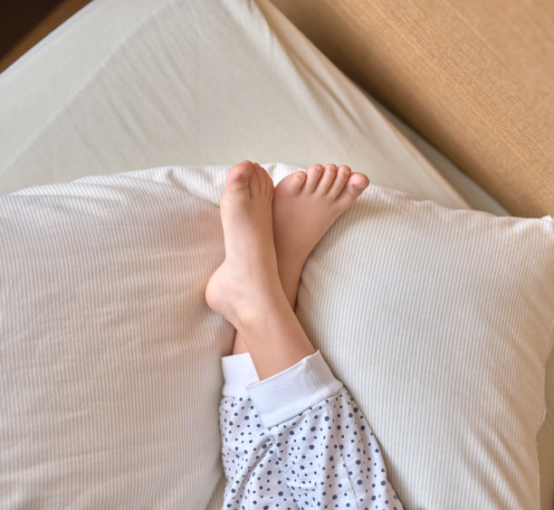 女孩的脚放在枕头上图片下载