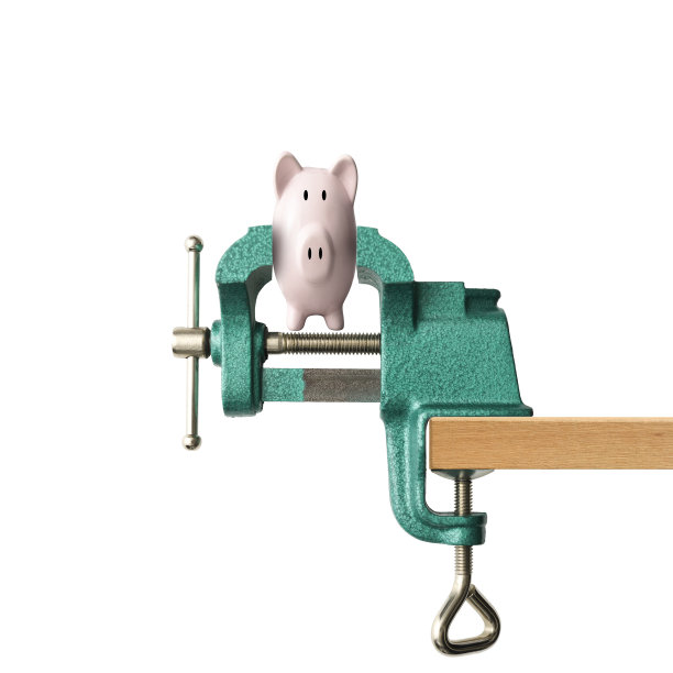 在白色背景下，用虎钳用力按压储蓄罐图片下载