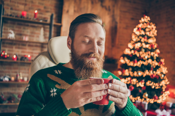 照片年轻快乐迷人的男人手牵手杯咖啡圣诞心情微笑室内室内的房子家图片下载