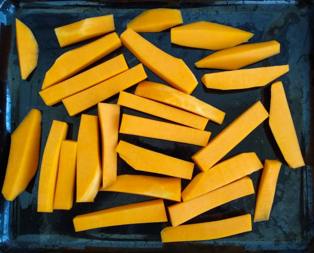 切好的南瓜片放在黑色烤盘上图片下载