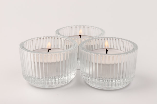 燃烧的茶蜡烛在一个玻璃烛台，孤立在白色。空间的文本图片下载