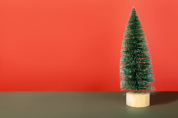 红色背景上的绿色微型闪亮圣诞树。本空间素材图片