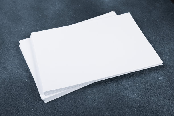 白色名片纸a4堆叠在黑暗的桌子上。冷的照片图片下载
