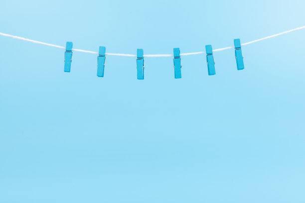 蓝色背景上的彩色卡通衣夹。副本的空间。图片下载