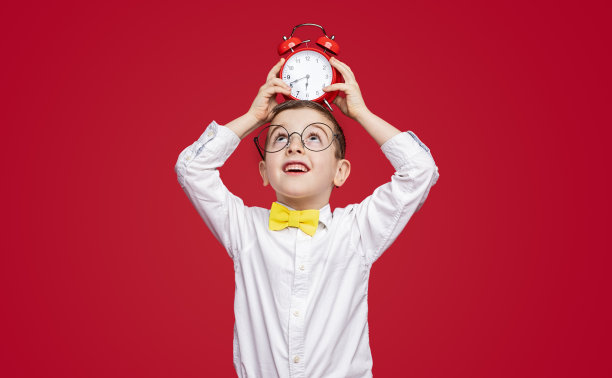 带着闹钟的滑稽小男孩图片下载