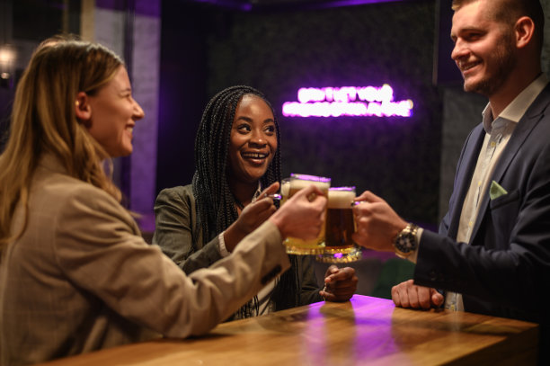 愉快的同事下班后一起在酒吧喝啤酒，玩平板电脑图片下载
