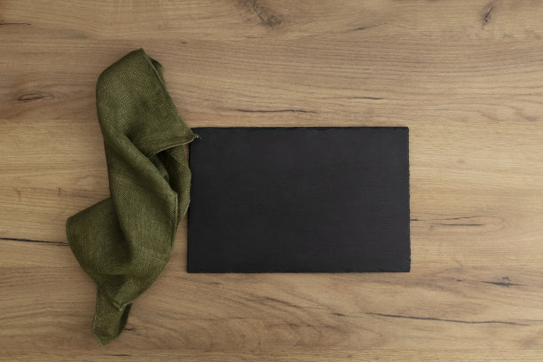 在木桌上的石板托盘，板和绿色亚麻餐巾的俯视图图片下载