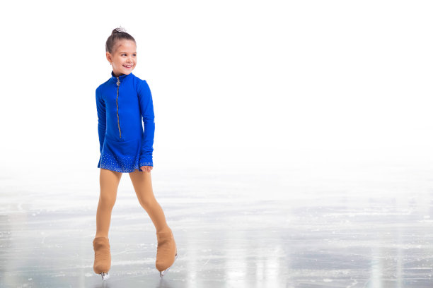 一个小花样滑冰运动员在蓝色训练服摆姿势在冰上的白色背景图片下载