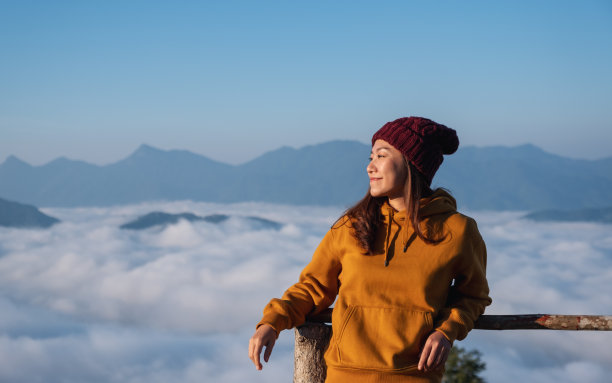 一个年轻的女旅行者的肖像与一个美丽的山和海雾图片下载