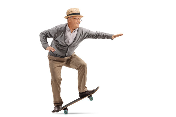 一个上了年纪的人在滑板上表演戏法的全长侧面照片图片下载