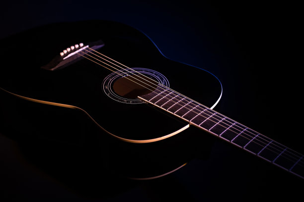 黑色背景的黑色吉他。吉他音乐低调概念图片下载