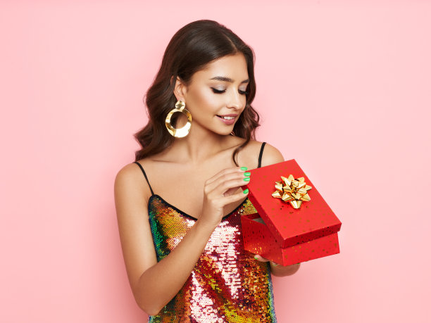 漂亮的女人穿着晚礼服，拿着礼品盒图片下载