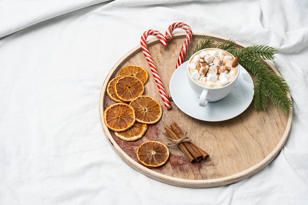 带棉花糖的咖啡杯，糖果手杖，床上的圣诞装饰。寒假的心情。圣诞节早上，咖啡时间。图片下载
