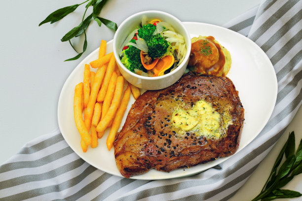 牛排薯条（肉、土豆、酱汁和蔬菜）图片下载