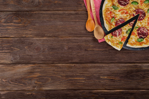 木质背景上带有切片的意大利辣香肠披萨，顶部有复制空间图片下载