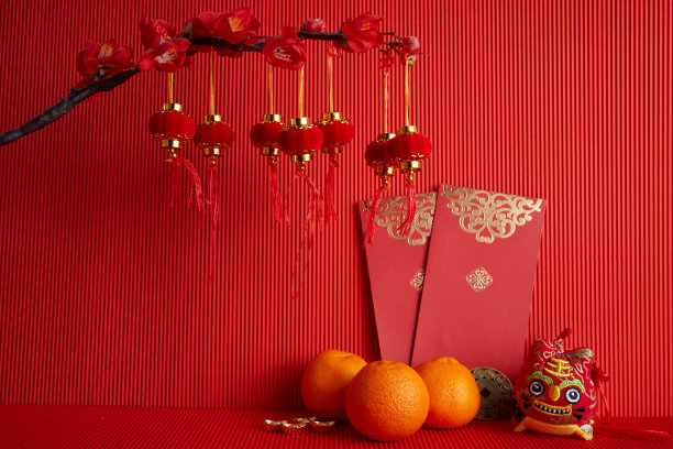 春节节日装饰。橙色，叶子，红色的包，梅花在红色的背景上。素材图片
