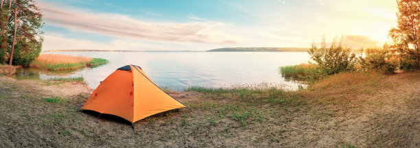 日出时沙滩上的橙色旅游帐篷图片下载