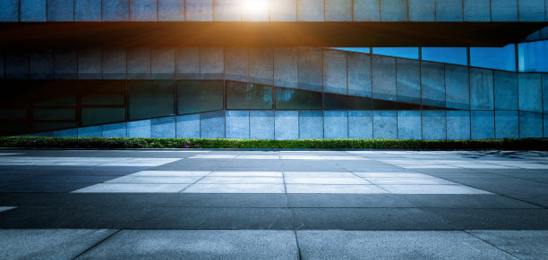 在晴朗的天空下，市中心建筑后面的石头广场素材图片