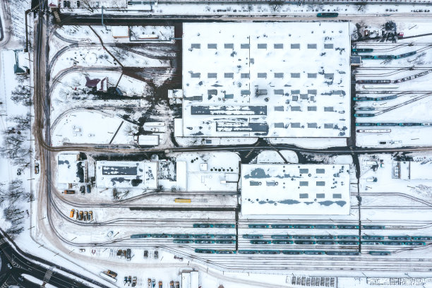 冬季多雾的电车站。城市工业区，建筑物被雪覆盖。空中无人机的照片。图片下载