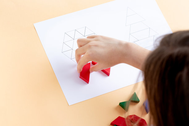 一个孩子在玩彩色积木。一个孩子在玩彩色积木。木制的形状圣诞节象征着圣诞树和花环图片下载