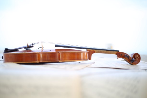 古典木小提琴，古老的手工制作的乐器，在复古乐谱乐谱单，自然的颜色，艺术音乐家近距离图片下载