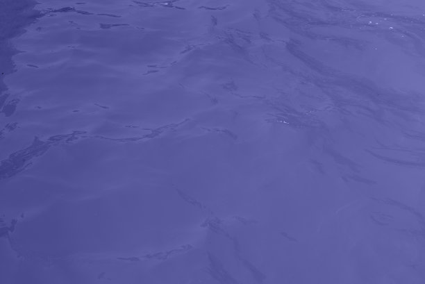 蓝色的水波纹理背景。起涟漪的水。闪闪发光的紫色和蓝色水面图片下载