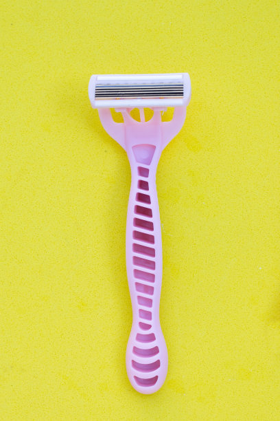 女性剃须刀在黄色背景图片下载