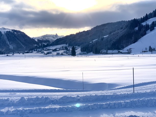 用两根杆子标记的越野滑雪道。瑞士施维茨州斯图顿山谷的冬季景色，以越野滑雪闻名。平坦的地形被群山环绕。图片下载