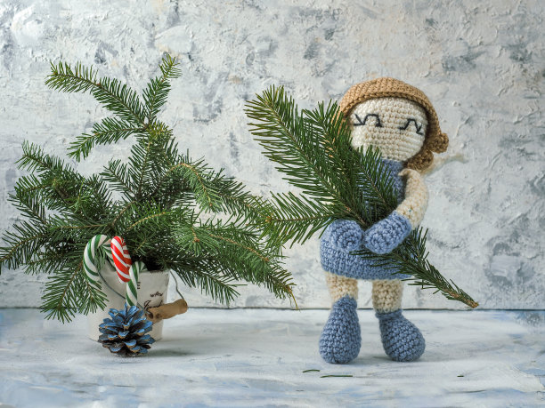 用冷杉枝编织的蓝色天使，还有陶瓷桶里的糖果图片下载