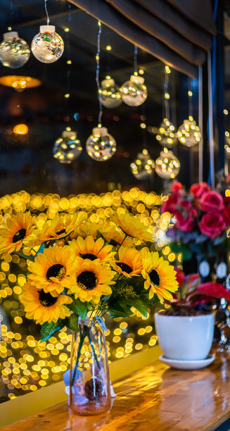 人造向日葵在玻璃花瓶装饰为圣诞装饰灯的形状在散景背景装饰在圣诞和新年。图片下载
