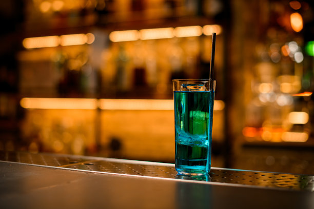 亮蓝色鸡尾酒杯，加冰和钢吸管图片下载