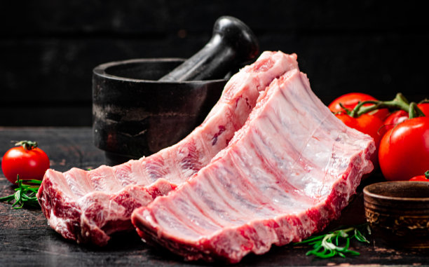 桌上放着香料和西红柿的生排骨。图片下载