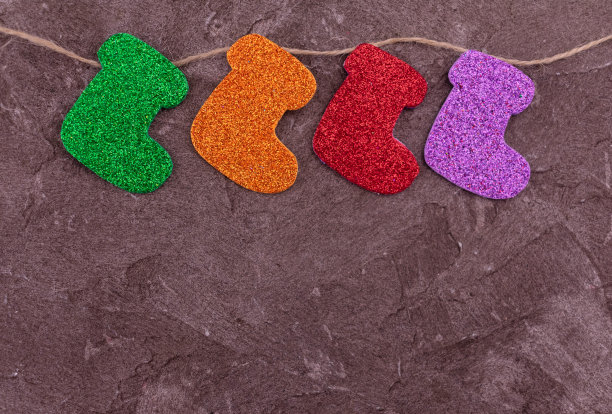 装饰好的圣诞袜挂在灰色背景上的绳子上。副本的空间。图片下载