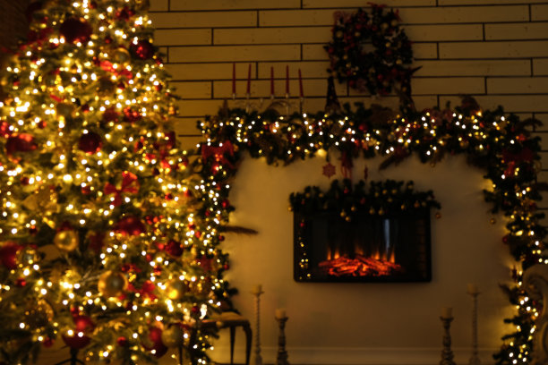 模糊照片的圣诞树与圣诞装饰灯和壁炉图片下载