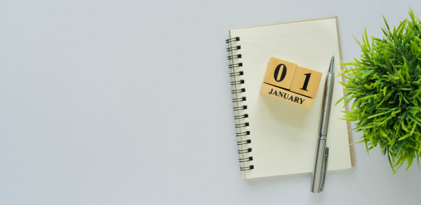 1月1日的木方块形状在空白的笔记本上，用钢笔在办公桌的背景上，为新年开始的决议和目标概念关闭顶视图图片下载
