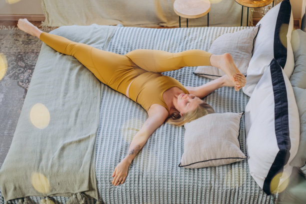 女运动员躺在床上，用毯子盖着图片下载